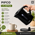 A black PIFCO 1.7L kettle being filled with water from a hand-held spout into a beige ceramic mug on a wooden coaster, with product text and features listed on the left and a Dropistan.